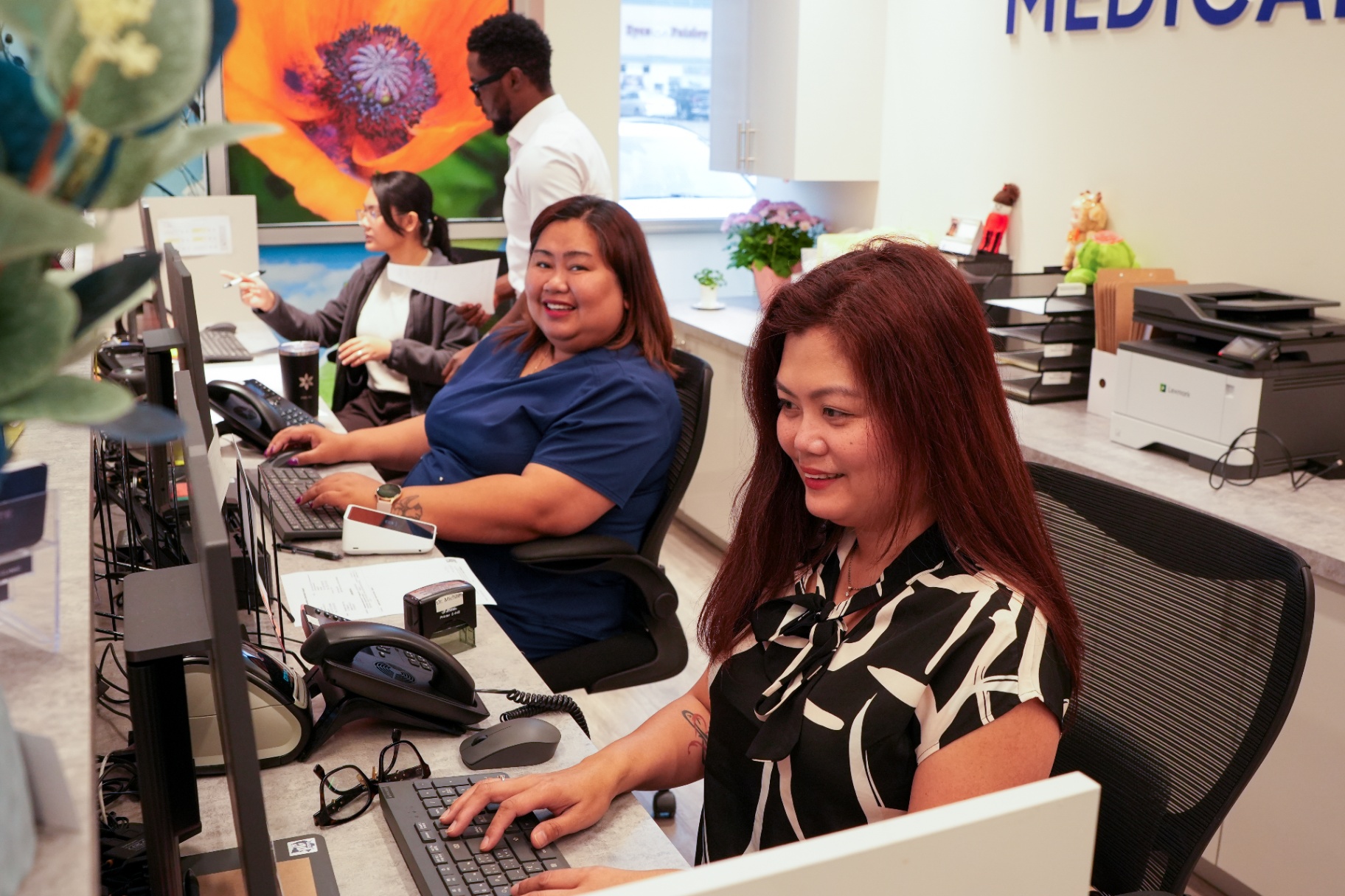 Reception staff working at the front desk computers